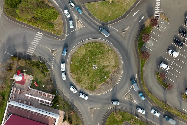 Aerial view of road roundabout intersection with fast moving\
heavy traffic urban circular transportation crossroads