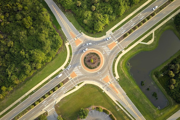 Aerial view of road roundabout intersection with moving cars traffic Rural circular transportation crossroads