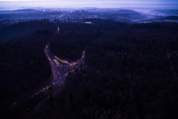 Photo aerial view of road through forest at night