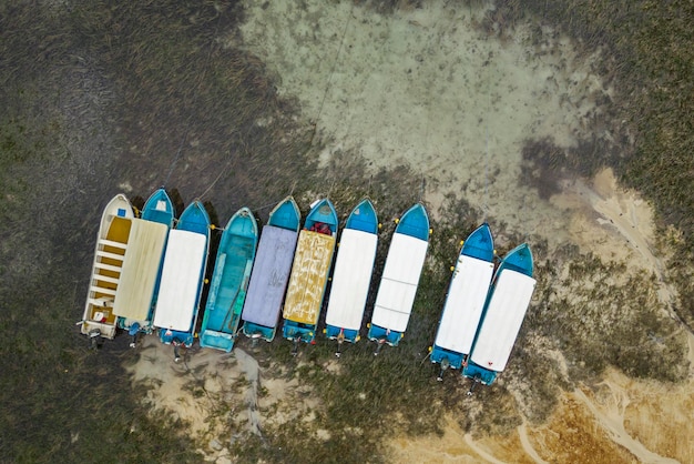 Aerial view of a row of fishing boats standing on the bottom at low tide