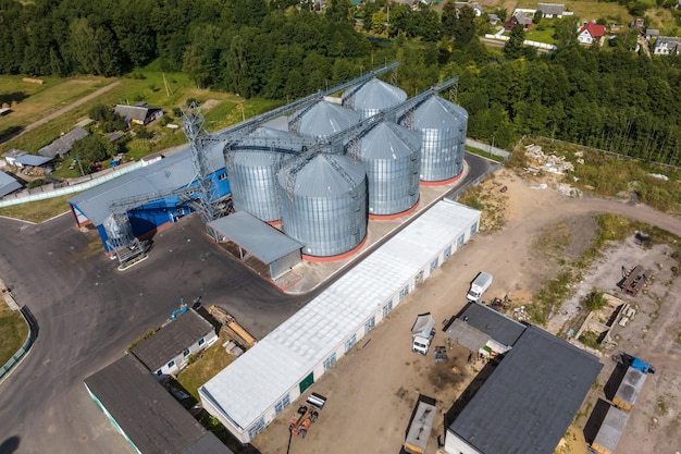 Aerial view on rows of agro silos granary elevator with seeds\
cleaning line on agroprocessing manufacturing plant for processing\
drying cleaning and storage of agricultural products