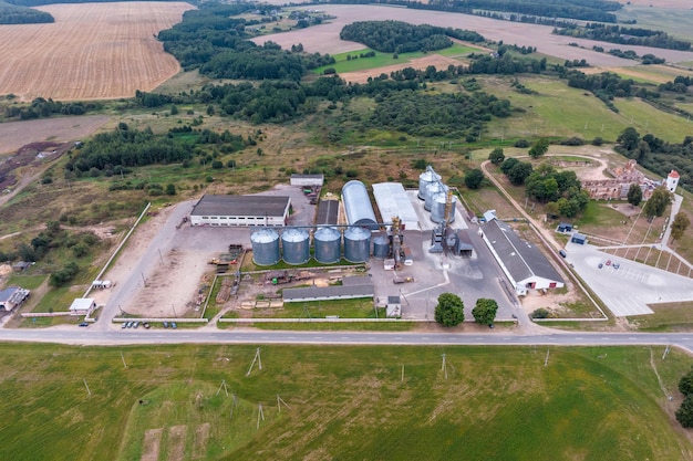 Aerial view on rows of agro silos granary elevator with seeds\
cleaning line on agroprocessing manufacturing plant for processing\
drying cleaning and storage of agricultural products