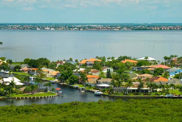 Aerial view of rural private houses in remote suburbs located on sea coast near Florida wildlife wetlands with green vegetation on gulf bay shore Living close to nature in tropical region concept