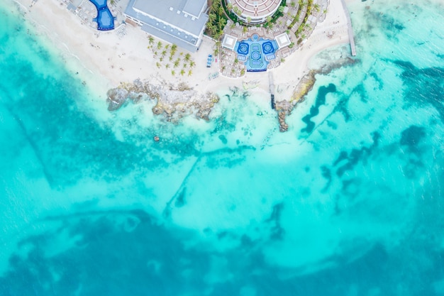 Aerial view of sandy beach and ocean with small waves in cancun mexico top view from drone playa