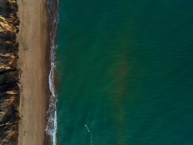Aerial view of sandy beach and sea with waves, Top view, amazing nature background, beach and clear water, flying drone, sea view, copy space.