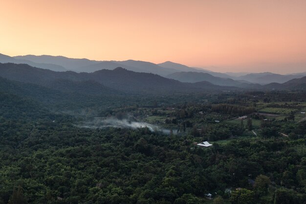 Aerial view of Scenery of colorful sky on green forest and mountain range in countryside