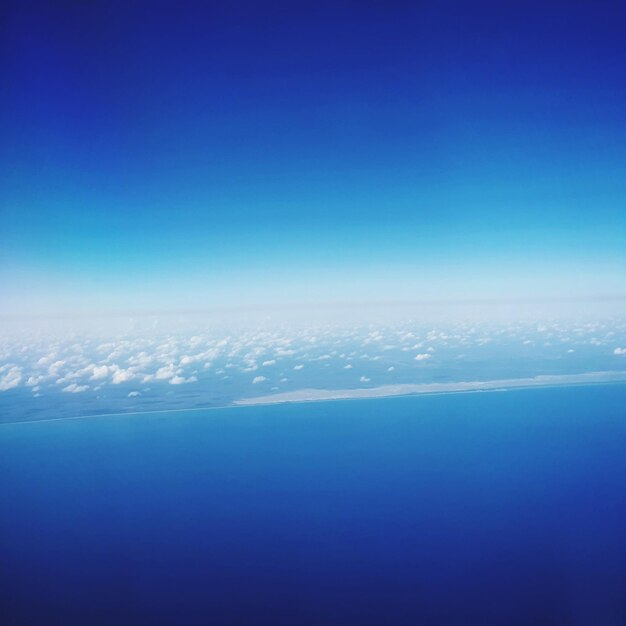 Aerial view of sea against blue sky