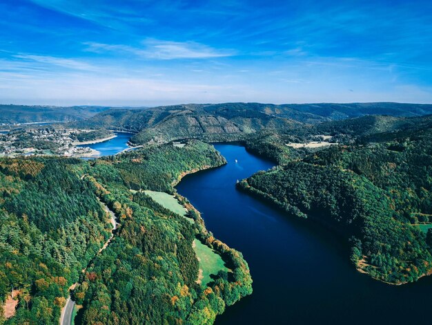 Photo aerial view of sea by mountain against blue sky