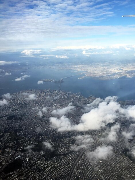 Aerial view of sea and cityscape against sky