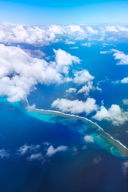 Foto vista aerea del mare, delle nuvole e della barriera corallina