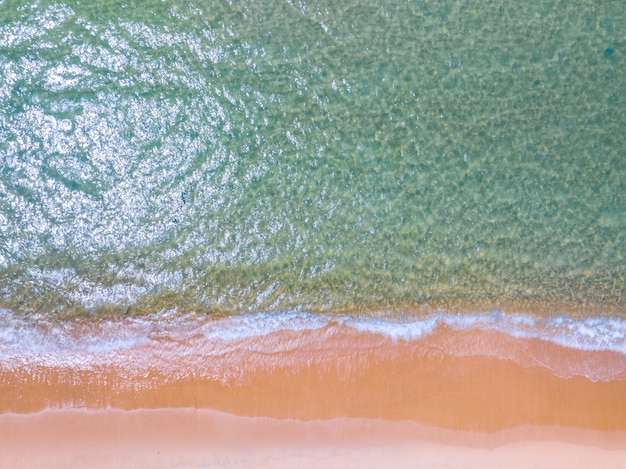 ビーチの砂上の白い泡状の波 ビーチの海面の上の景色 自然の海 ビーチの砂の背景