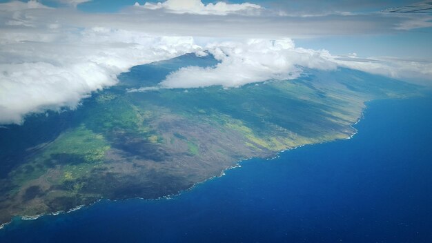 aerial view of sea and mountains against cloudy sky