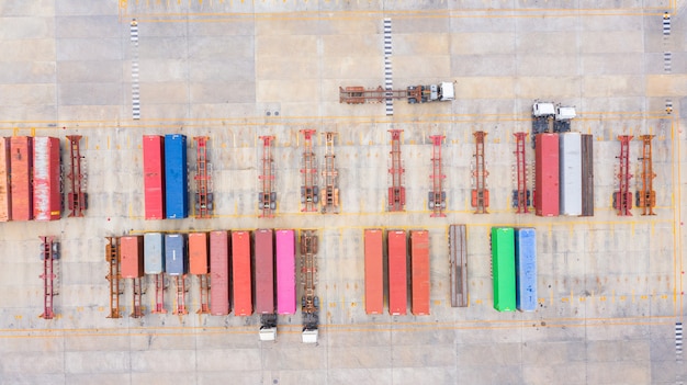 Aerial view semi truck with cargo trailer parking with other trucks on industrial port parking Lot.