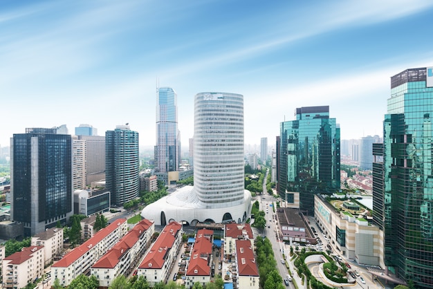 Aerial view of Shanghai's high density central business area. High rise office buildings and skyscrapers with glass surface. Urban roads with multiple lanes and green city park. Shanghai, China