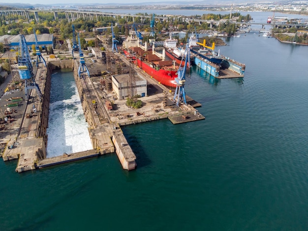 Aerial view shipyard dry dock maintenance and repair cargo ship\
transport and oil ships in sea