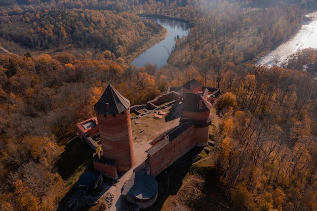 Aerial view of the Sigulda city in Latvia during golden autumn. Medieval castle in the middle of the forest.