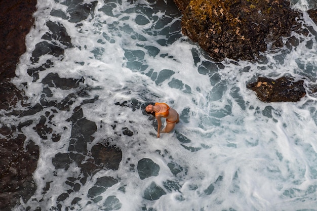 Aerial view of slim woman sunbathing lying on a beach in hawaii