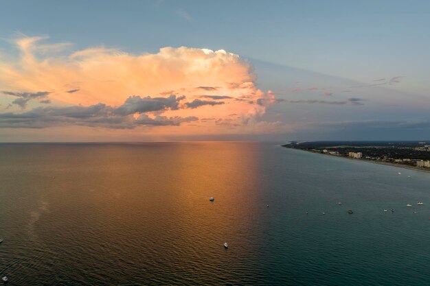 Aerial view of small yachts at sunset floating on sea waves with ripple surface Motor boats recreation on ocean surface