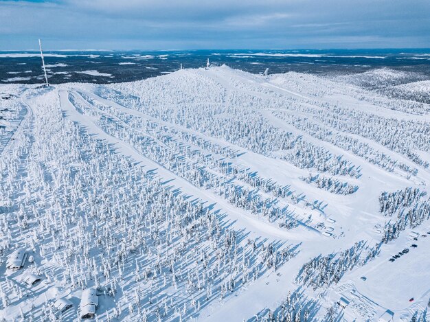 Aerial view of snow covered forest and ski resort slope in winter Finland Lapland Drone photography from above
