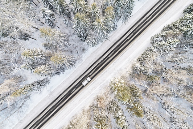 Aerial view of snow covered road in winter forest