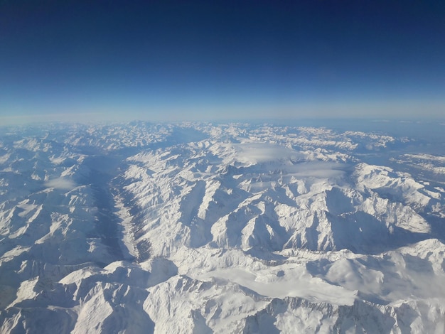 Foto vista aerea di una montagna innevata contro il cielo blu