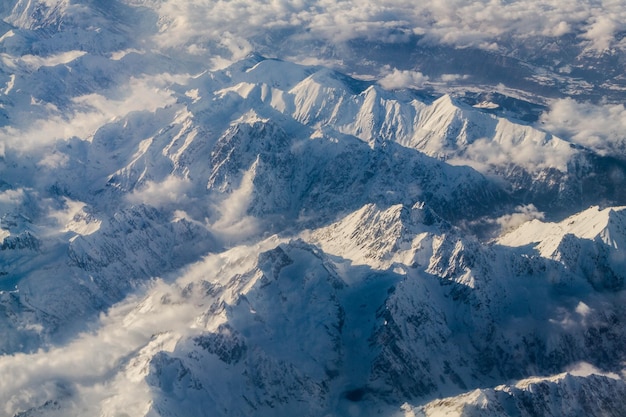 空から見ると天空を背景に雪で覆われた山々