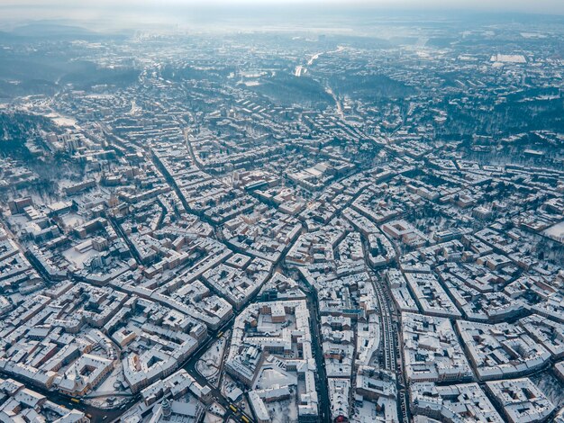 Aerial view of snowed lviv center copy space city blocks\
directly above