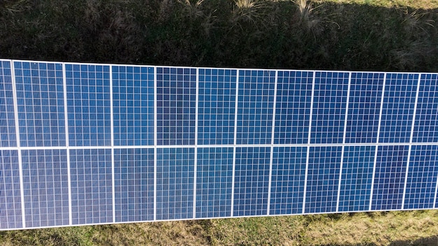 Аэрофотоснимок солнечных батарей на экологической ферме. Электротехнические инновации в природной среде.