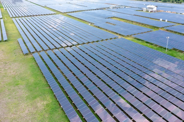 Aerial view of solar panels or solar cells on the roof in farm. Power plant with green field, renewable energy source in Thailand