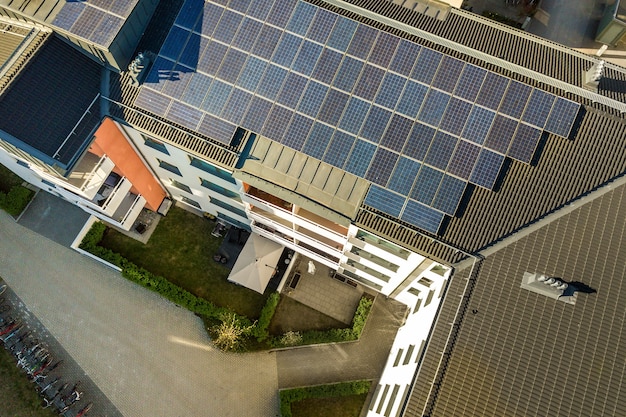 Aerial view of solar photovoltaic panels on a roof top of residential building block for producing clean electric energy. Autonomous housing concept.