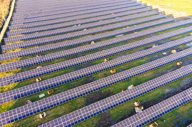 グリーンフィールドに建設中の太陽光発電所の航空写真。クリーンな生態学的エネルギーを生み出すための電気パネルの組み立て。