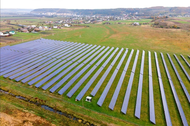 グリーンフィールド上の太陽光発電所の航空写真。クリーンな生態学的エネルギーを生産するためのパネルを備えた電気農場。