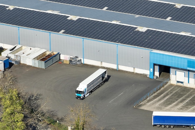 Aerial view of solar power plant with blue photovoltaic panels mounted on industrial building roof for producing green ecological electricity Production of sustainable energy concept