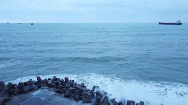 Aerial view of stormy sea with concrete pier