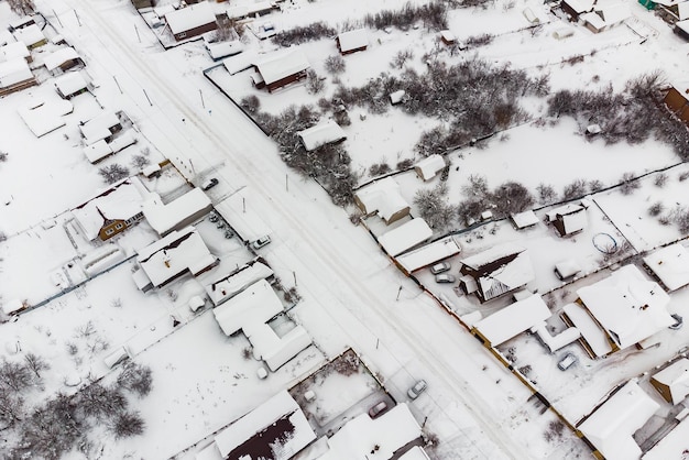 눈 덮인 겨울날 눈 덮인 마을에 집들이 있는 거리의 공중 전망