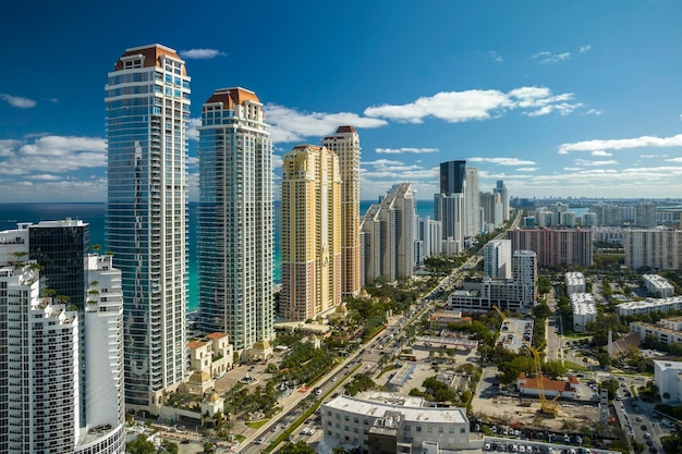 Aerial view of Sunny Isles Beach city with luxurious highrise hotels and condos on Atlantic ocean shore American tourism infrastructure in southern Florida