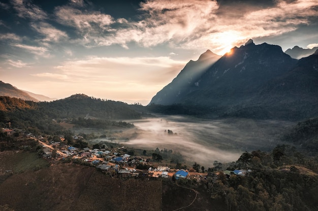 Aerial view of sunrise over Doi Luang Chiang Dao mountain range with foggy and local traditional village on hill in tropical rainforest at Ban Na Lao Mai Chiang Dao Chiang Mai Thailand