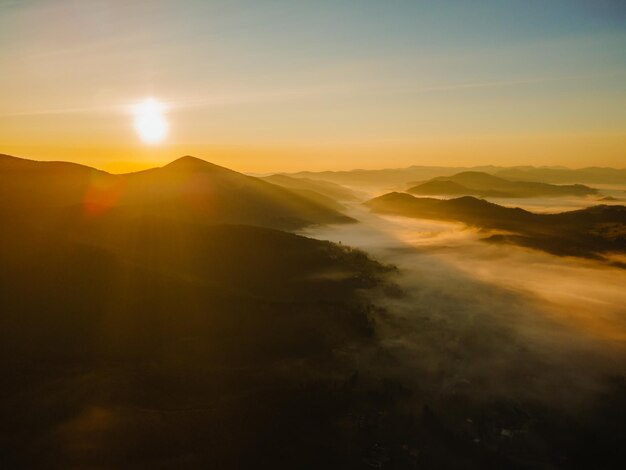 Aerial view of sunrise above mountain range copy space