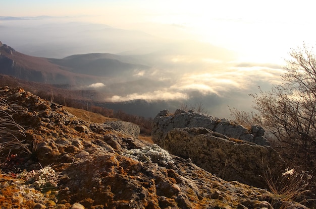 aerial view of sunrise in the mountains with orange reflex on sky clouds over sea rocks and valley