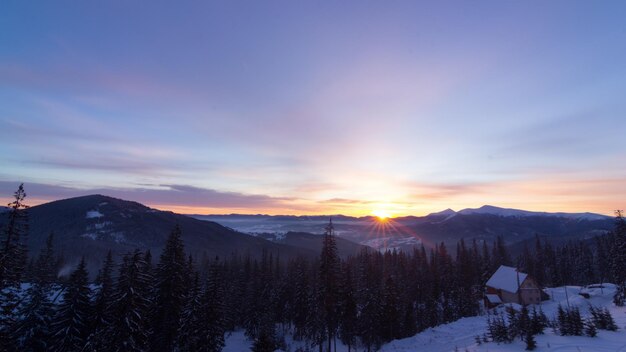 Aerial view of sunrise in winter forest mountains with lot of
snow and snowy trees in cold morning nature landscape