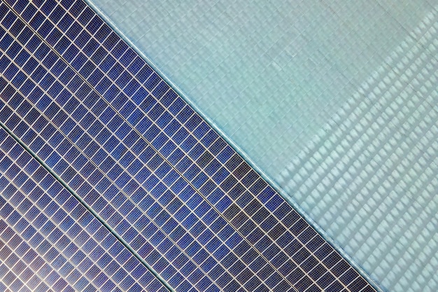 Aerial view of surface of blue photovoltaic solar panels mounted on building roof for producing clean ecological electricity Production of renewable energy concept