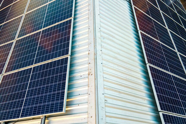 Aerial view of surface of blue photovoltaic solar panels mounted on building roof