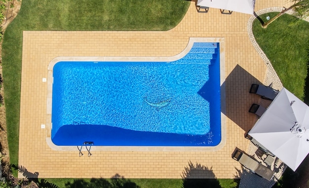 Aerial view of swimming pool outside hotel.