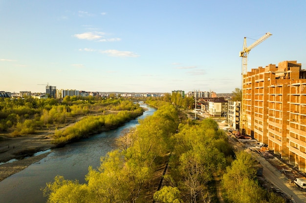 Aerial view of tall residential apartment buildings under construction and Bystrytsia river in Ivano-Frankivsk city, Ukraine.