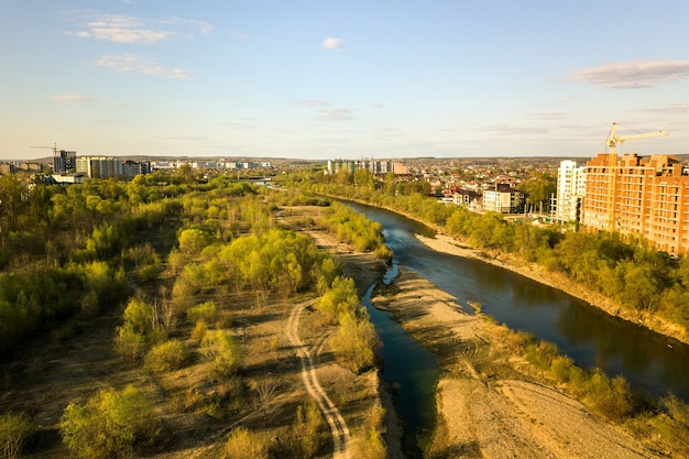 Aerial view of tall residential apartment buildings under construction and Bystrytsia river in Ivano-Frankivsk city, Ukraine.