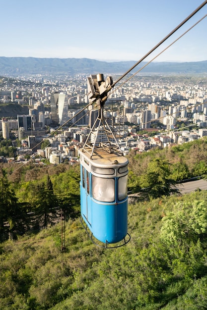 町の上の山ジョージア古い青いケーブルカーキャビンからのトビリシの町の航空写真