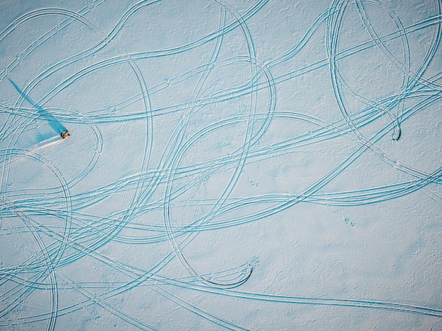Foto veduta aerea di tracce di pneumatici su un campo coperto di neve