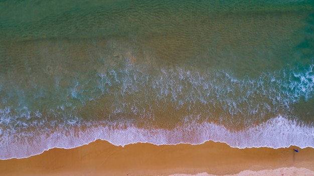 Aerial view Top view Amazing nature background of sea beach wave crashing on sandy shore and clear water of Phuket Thailand ocean at sunset or sunrise time.