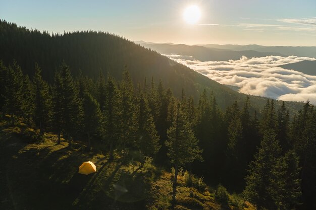 明るい晴れた夜の山のキャンプ場の観光キャンプテントの空撮。アクティブな観光とハイキングのコンセプト。