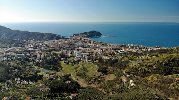 Aerial view of townscape by sea against sky